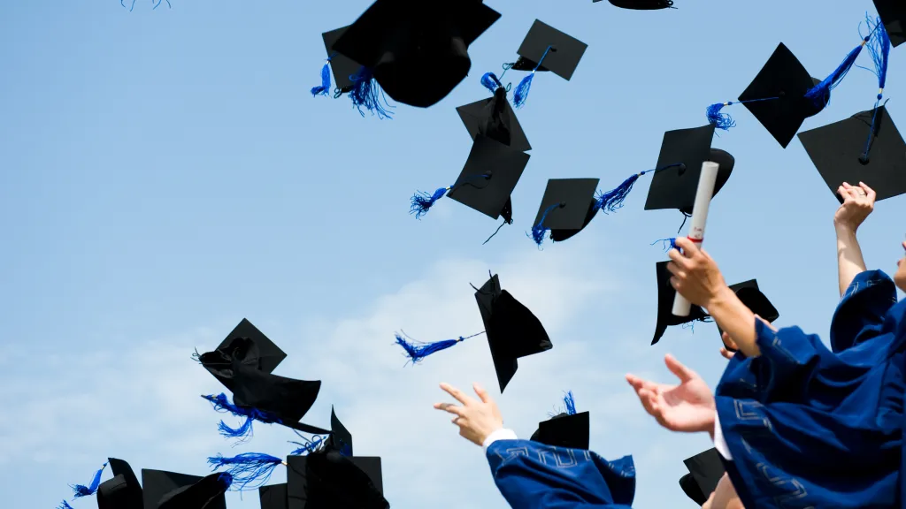 Students throwing their graduation caps in the air.